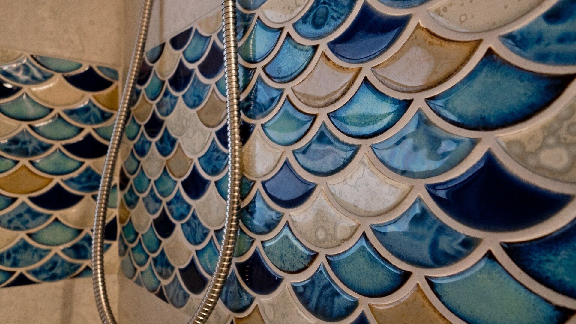 A close-up of a tiled wall with a scale-like pattern.