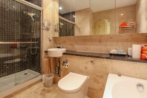 Un baño con ducha de mampara, inodoro, lavabo y bañera.