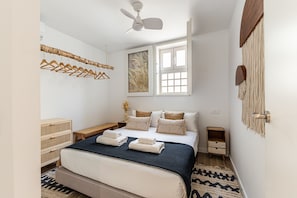 A bedroom with a bed, a ceiling fan, a window, and a wall-mounted towel rack. - Waou Plaza de Oriente es MIA - Corta Duración (Madrid)
