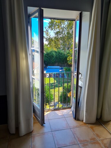 Chambre double avec vu sur jardin paysager et piscine dans maison de charme