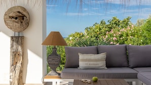 Una sala moderna con un sofá gris, una lámpara decorativa y vistas a zonas verdes.