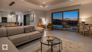 Una sala moderna con sofá, una mesa de comedor y un balcón con vistas.