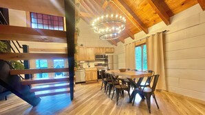 Una cocina moderna con armarios de madera, una isla central y una araña.