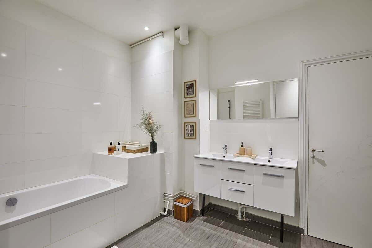 Un baño moderno con una bañera, un tocador con espejo y un inodoro.