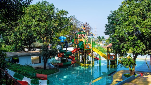 Ein Wasserpark mit Rutschen und Poolbereich, umgeben von Bäumen.