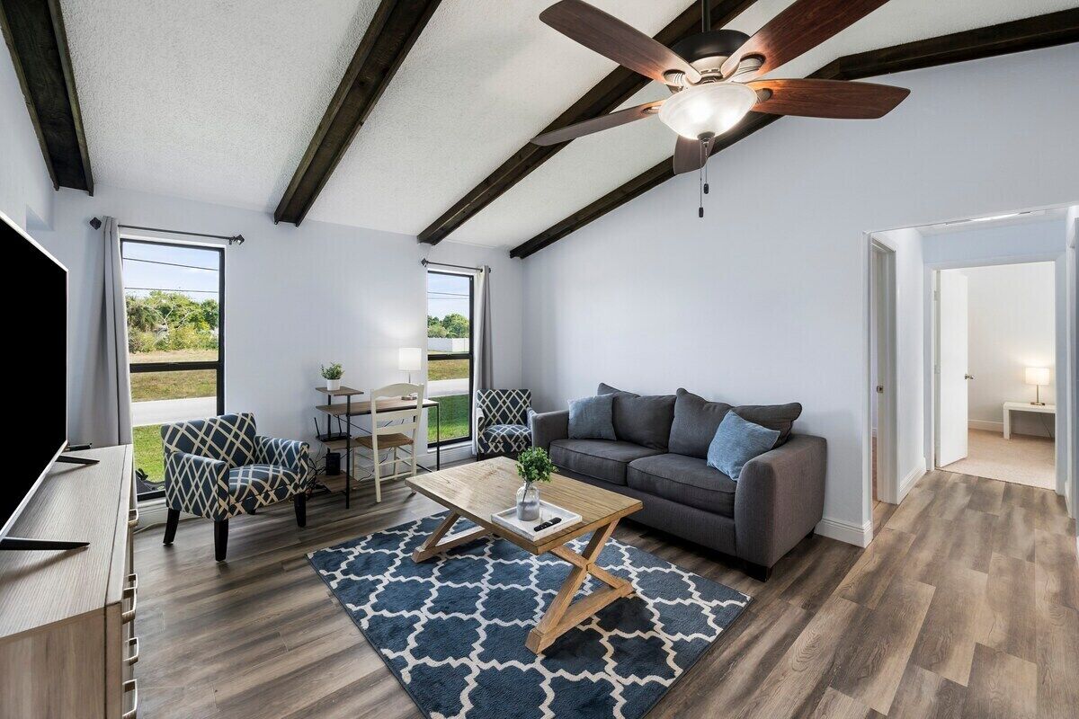 A modern living room with a wooden ceiling, a sofa, a coffee table, and a TV.