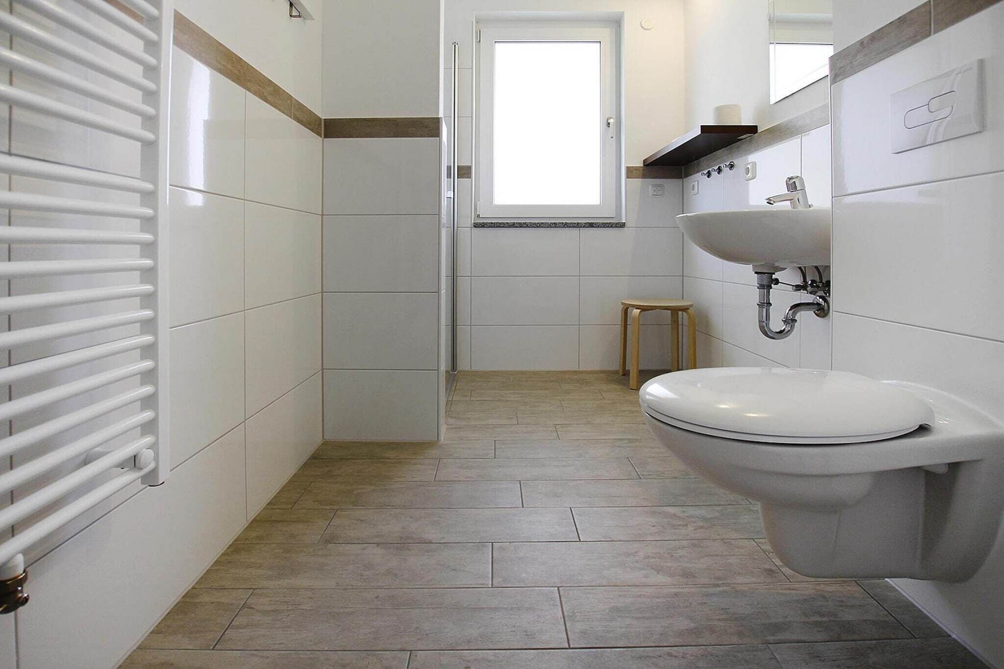 Un bagno moderno con termosifone bianco, un water e un lavandino.