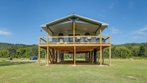 A two-story house with a balcony, a garage, and a lawn. - Melbourne Home w/ Fire Pit on the White River! (Melbourne)