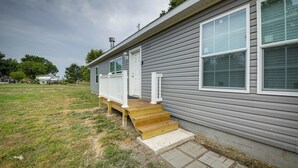 A single-story house with a front porch, a visible door, and a chimney. - Efficiently Equipped Lewis Home: Deck & Gas Grill! (Lewis)