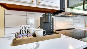 A kitchen with white cabinets, a coffee maker, and a tray with coffee mugs and a sign that reads "Coffee Bar". - Lovely Montgomery Home ~ 7 Mi to Downtown! (Montgomery)