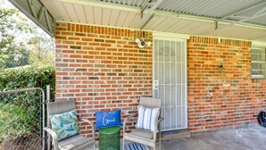 A covered porch with wicker chairs and a green trash can. - Lovely Montgomery Home ~ 7 Mi to Downtown! (Montgomery)