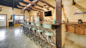 Eine Bar mit Holzbalken, einem Coors Light Schild und einem Fernseher an der Wand.