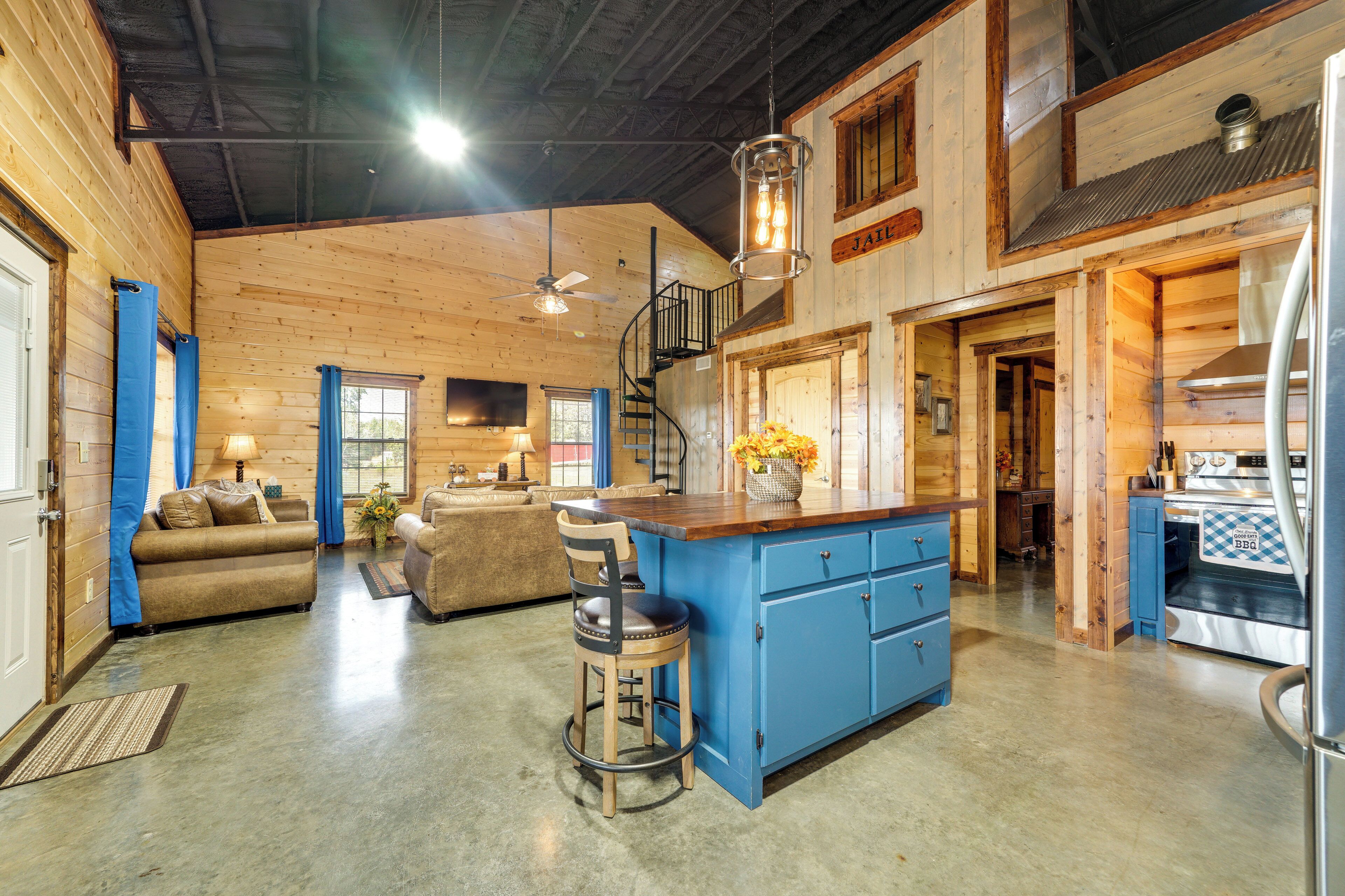 A spacious log cabin interior with a kitchen, dining area, and living room.