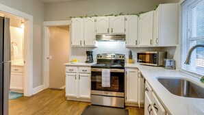 A modern kitchen with white cabinets, stainless steel appliances, and a large window. - Spokane Vacation Rental w/ Central Location! (Spokane)