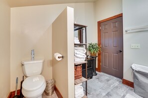 A bathroom with a toilet, a sink, a mirror, and a towel rack.