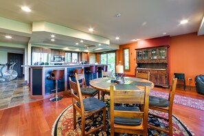 A spacious kitchen with a central island, wooden cabinets, and a dining area with a round table and chairs.