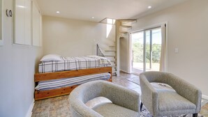 A bedroom with a bed, two armchairs, a staircase, and a large window. - 1 Mi to Whiskey Row: Home w/ Fire Pit & Deck (Prescott)