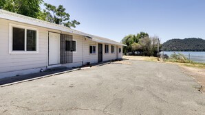 A single-story mobile home with a front door, windows, and a paved driveway. - Quiet Lakefront Clearlake Vacation Rental! (Clearlake)