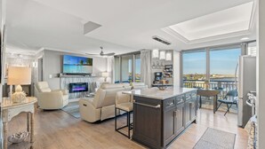 Una sala de estar moderna con chimenea, televisor y balcón con vistas.