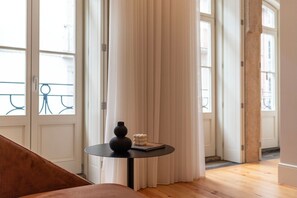 Enjoy a view of the outside from this room's large window, featuring a comfortable sofa and a stylish table with a decorative centerpiece.