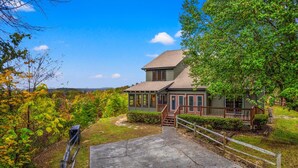 A two-story house with a porch and a staircase leading to the entrance. - Winter Wonderland of fun near Attractions (Sevierville)