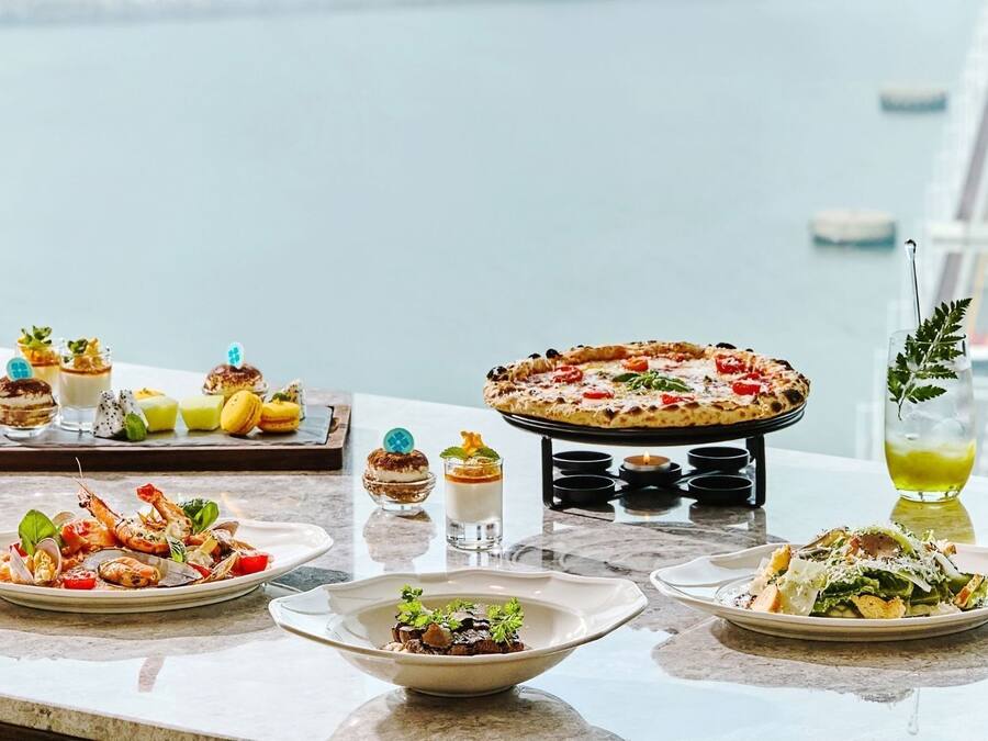 Una variedad de platos y bebidas sobre una mesa con vista al mar.