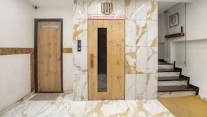 A hotel entrance with a wooden door labeled "WASH ROOM" and a sign above stating "LIQUOR IS STRICTLY NOT ALLOWED". - Treebo Urban, 1 Km From Railway Station (Surat)