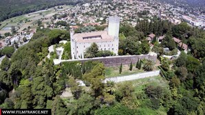 An aerial view of a historic castle surrounded by dense greenery and a town in the background. - Studio Port Marina Baie des Anges (Villeneuve-Loubet)
