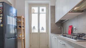 A compact kitchen with a refrigerator, a sink, and a stove. - La Casa dei Viaggiatori by Wonderful Italy (Turin)