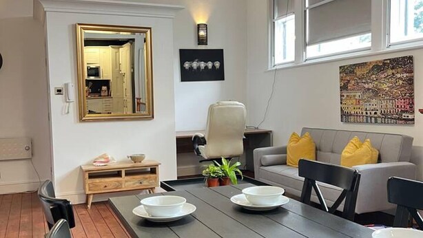 A dining area with a long table, chairs, and a modern pendant light. - Stunning 2-bed Apartment in Maidstone (Maidstone)
