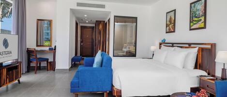 Una habitación de hotel con cama, escritorio, silla, televisión y una mesa de comedor con frutas.
