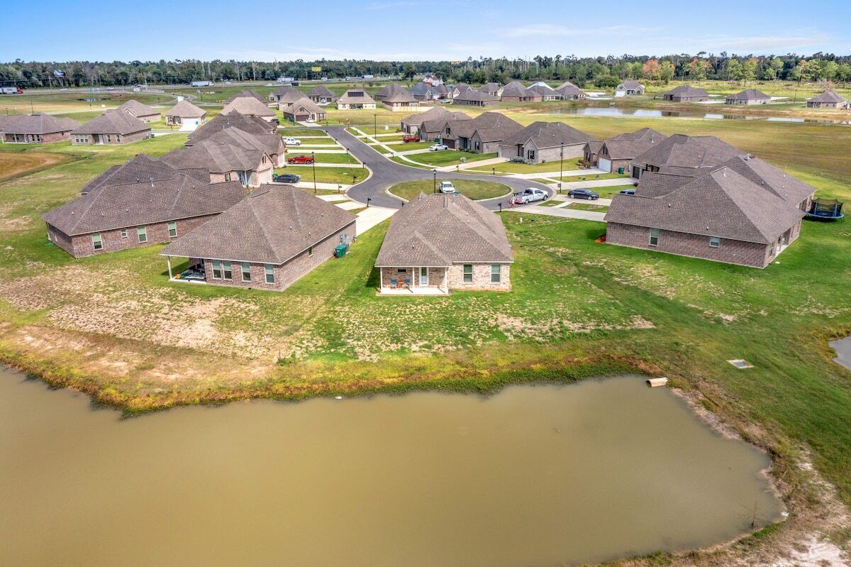 Un barrio residencial con casas, una calle principal y una masa de agua.