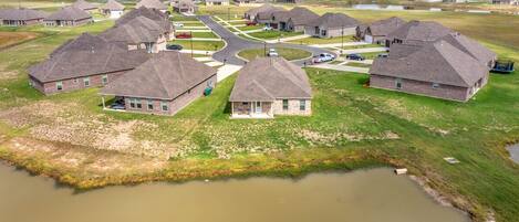 A residential area with houses, a central road, and a body of water.