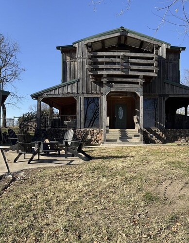 Rustic Lodge with a view of open pastures and bison grazing on the land. 