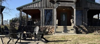 Rustic Lodge with a view of open pastures and bison grazing on the land. 