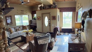 Un salon chaleureux avec un canapé, des fauteuils, une table basse et une cheminée.