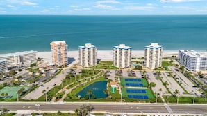 A coastal hotel complex with multiple high-rise buildings, a beach, and a parking area. - Beachfront Condo in Fort Myers Beach (Fort Myers Beach)