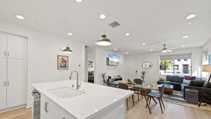 A modern kitchen with a central island, white cabinetry, and recessed lighting. - Gated PGA West 2023 New Build (EV Charger) (La Quinta)