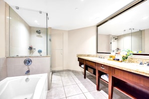 Une salle de bain moderne avec une douche à parois de verre, un grand miroir et un comptoir en marbre.