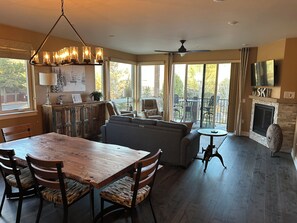 A spacious living area with a dining table, sofas, and a fireplace.