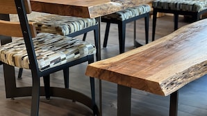 A dining area with wooden tables and chairs, featuring a rustic design with visible wood grain and metal legs. - Luxury Dillon Ski Condo – 2 Master Suites, Heated Garage + Near 7 Ski Resorts (Dillon)