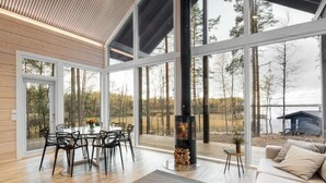 Een modern interieur met een eethoek, grote ramen en een open haard.