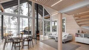 Een modern interieur met een eethoek, een open haard en een bank.