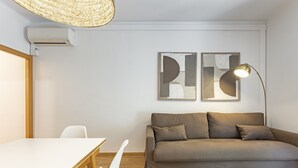 A modern living room with a sofa, a table, and a lamp. - SAGRADA FAMILIA (Barcelona)