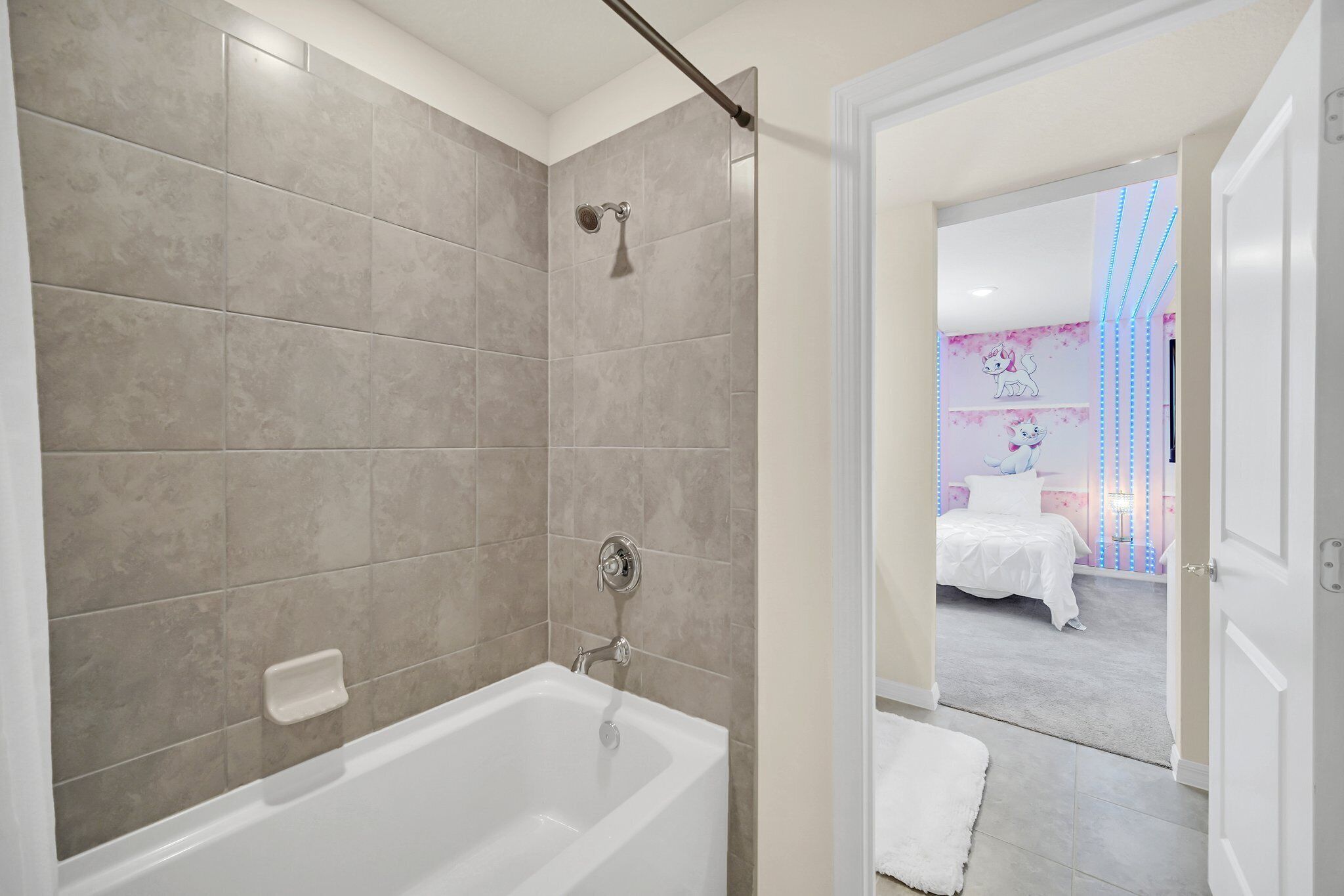A modern bathroom with a bathtub, shower, and tiled walls.