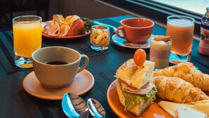 Una mesa de desayuno con vista al océano, que incluye una palmera y una playa.