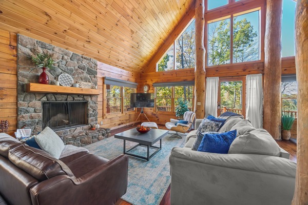 Main level living room with beautiful stone fireplace and stunning lake views