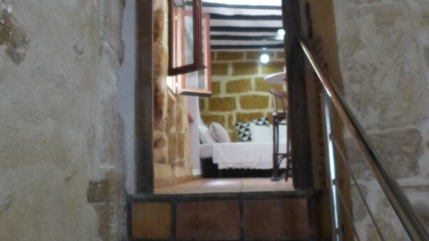 A narrow staircase with stone walls and a wooden handrail. - Authentic Escape: Tosca Stone Studio in Javea (Xàbia)