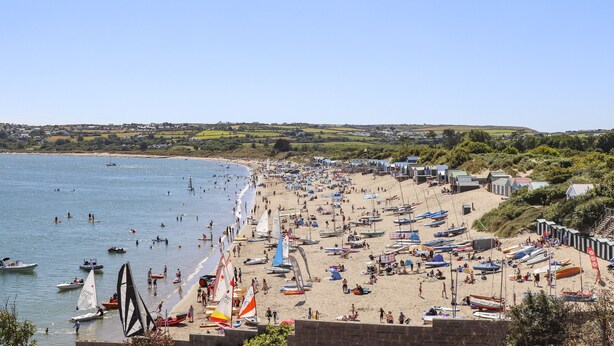 Une plage où l’on voit de nombreux bateaux et beaucoup de monde.