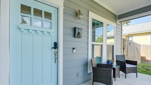 A light blue door with a window, a wall-mounted light fixture, and a small picture frame.